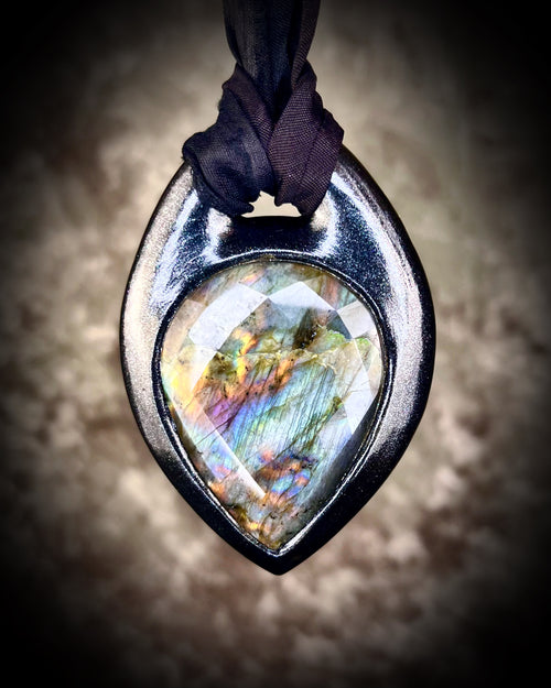 Handmade designer flashy labradorite rainbow teardrop shaped faceted crystal talisman is finished in black and hung from black recycled silk for a spooky eco-friendly elegance. 